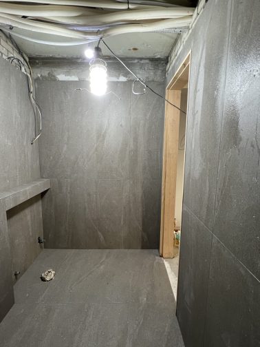 짙은 어두운색의 느낌이 나는 타일을 1200x600 세로시공된 모습