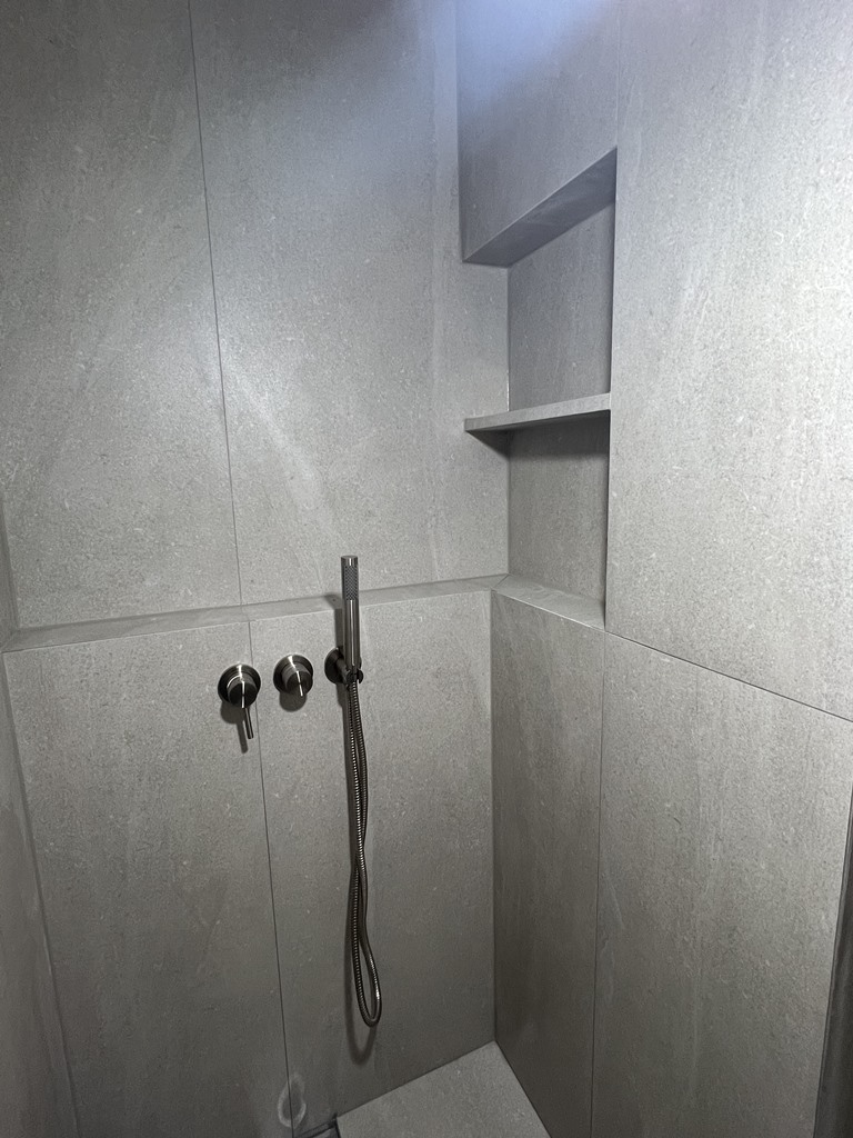 1200 x600 포쉐린타일로 꾸민 샤워부스 내부, 타일로 마감한 샤워부스 파티션에 선반을 만들어 보다 더 실용성 높임