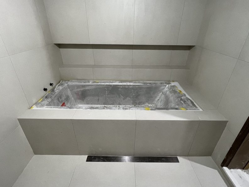 욕조의 날개부분의 타일을 욕조보다 높여 물을 욕조안으로 배출
