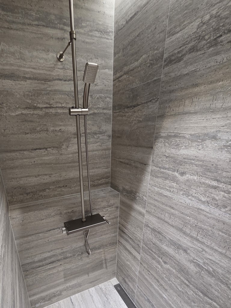 브러시드 니켈 샤워 수전이 설치된 샤워공간