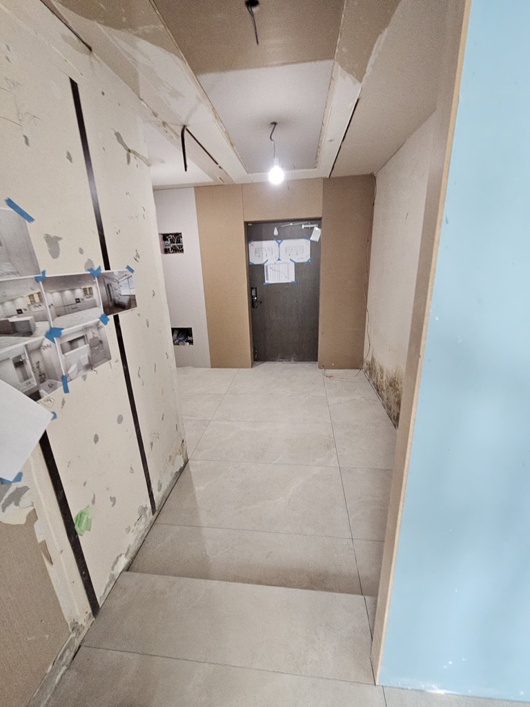 거실 바닥과 줄눈 라인을 맞춰 현관까지 이어지도록 시공한 1200x600 포세린 타일