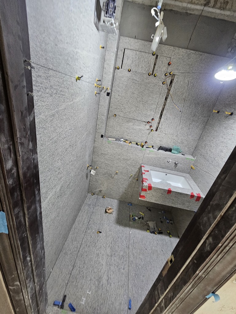 수건장 뒤 가려지는 부분에 재단 타일을 사용해 자재 로스를 줄이는 욕실 타일 시공 과정