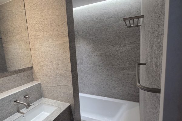 욕조 상부 간접조명이 설치된 분위기 있는 공용욕실 타일 마감