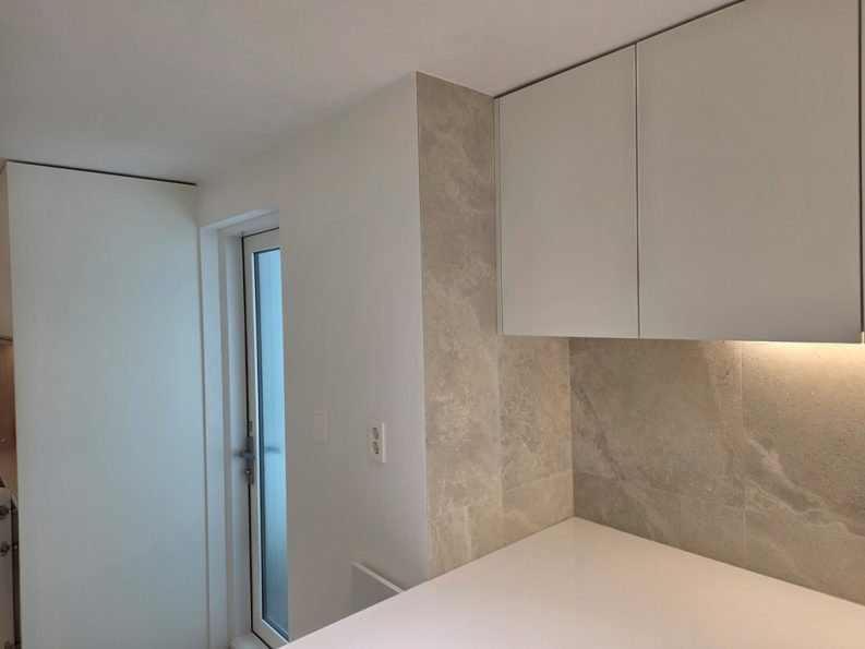 주방 코너 벽면에 세로로 시공된 1200x600 포세린 타일 디테일